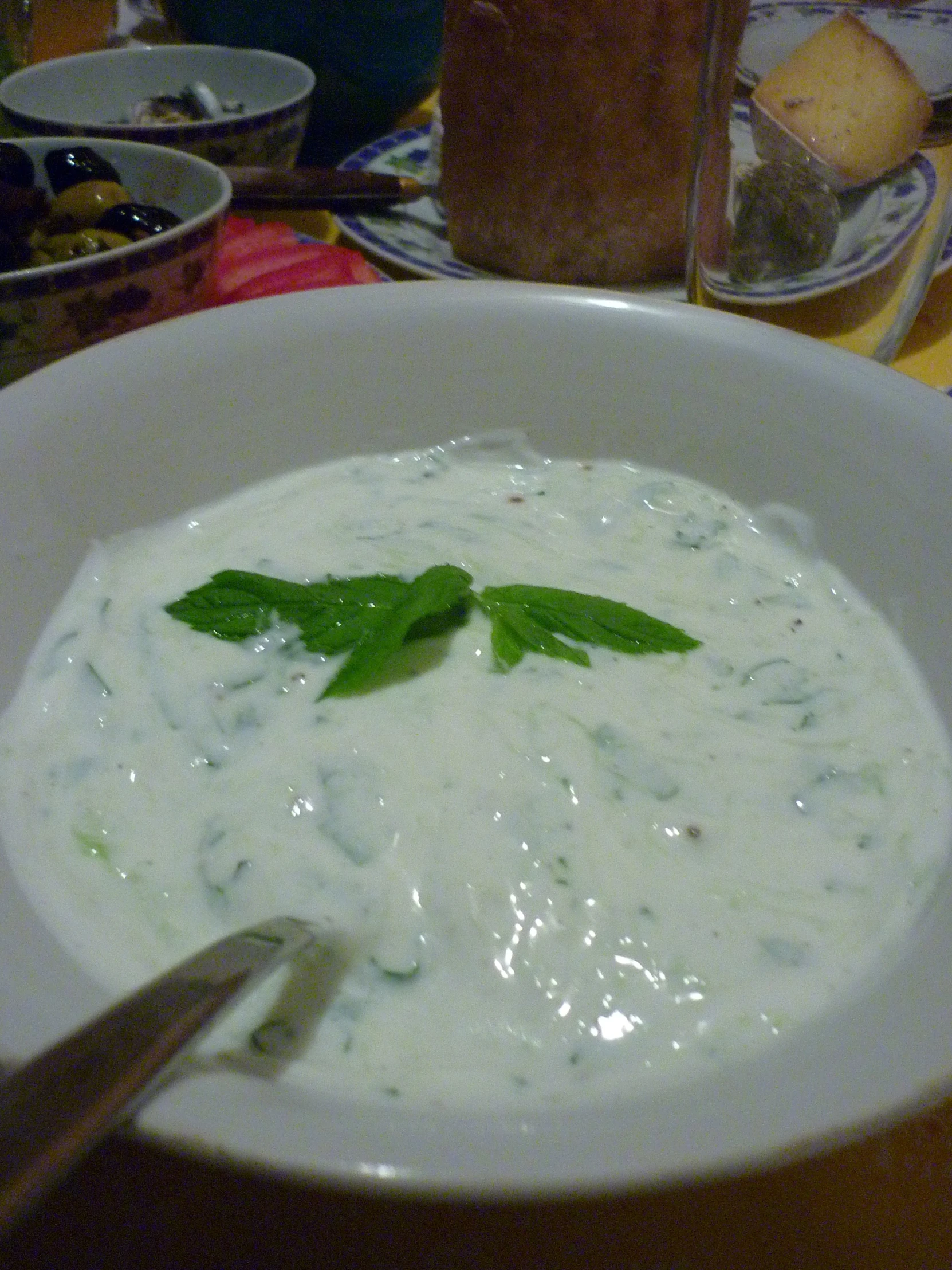 there is a bowl of white soup with green leaves