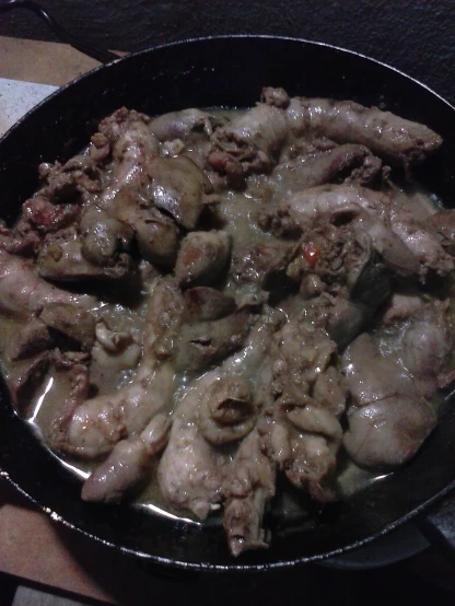 chicken pieces are cooking in a pan on the stove