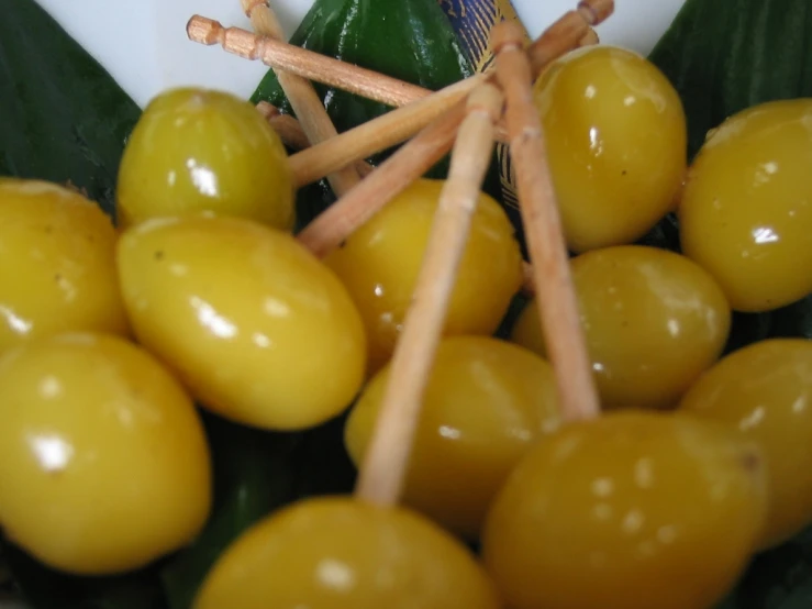 olives are piled on top of bamboo skewers