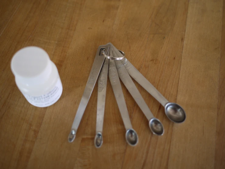 five pairs of scissors are on the table next to a bottle