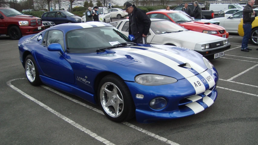 a blue and white sports car parked in a parking lot