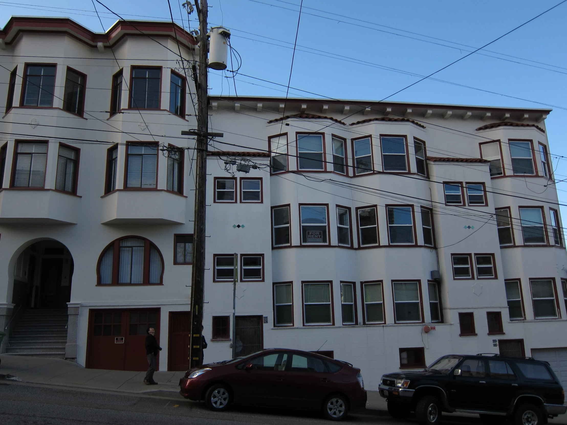 two cars are parked next to the big building