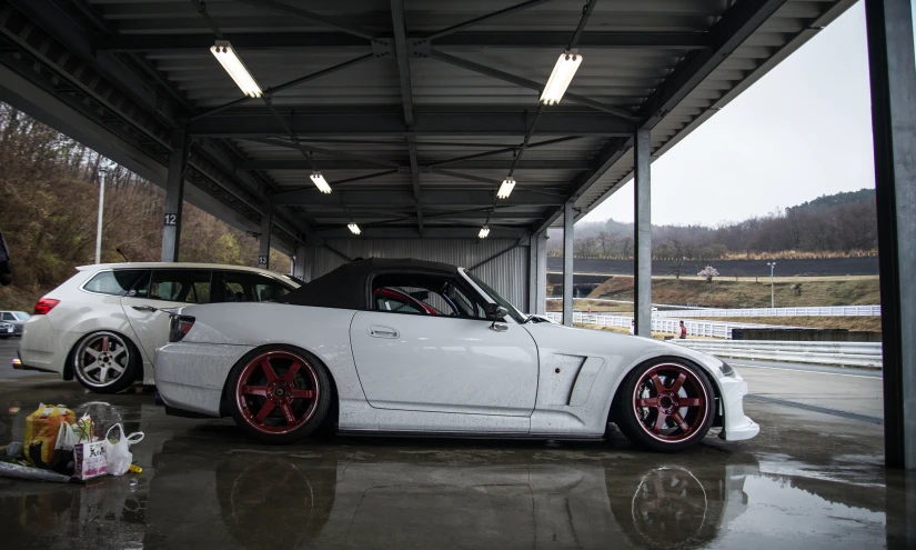 a white sports car is parked in an indoor space