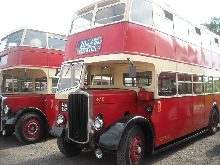 a row of red and white double decker buses parked next to each other