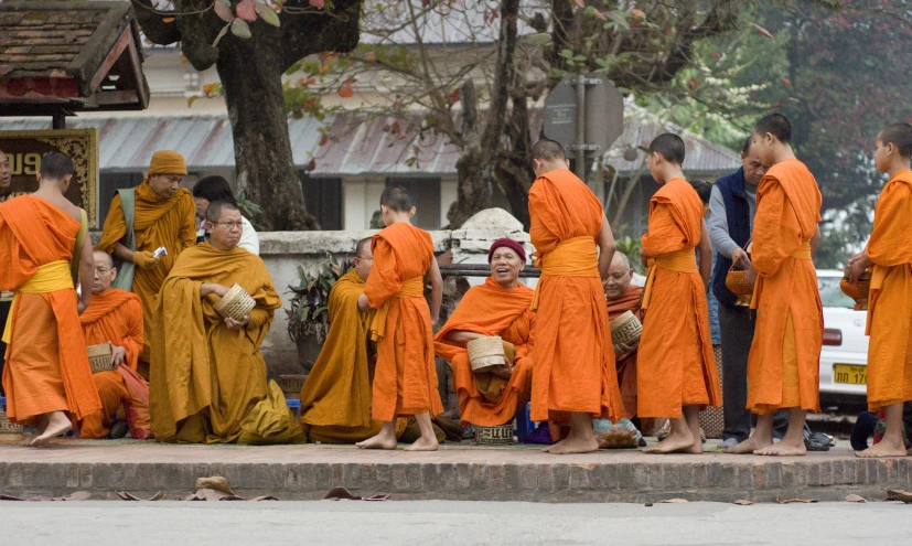 people dressed in orange are standing on the curb