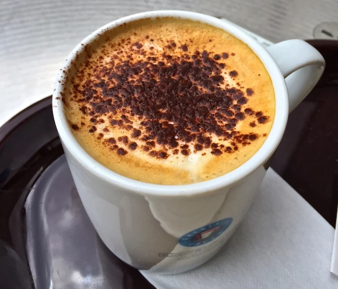 a cappuccino is sitting in a white cup