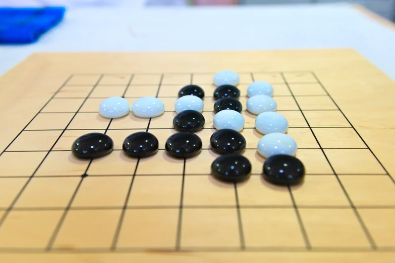 an oriental board game with black and white balls