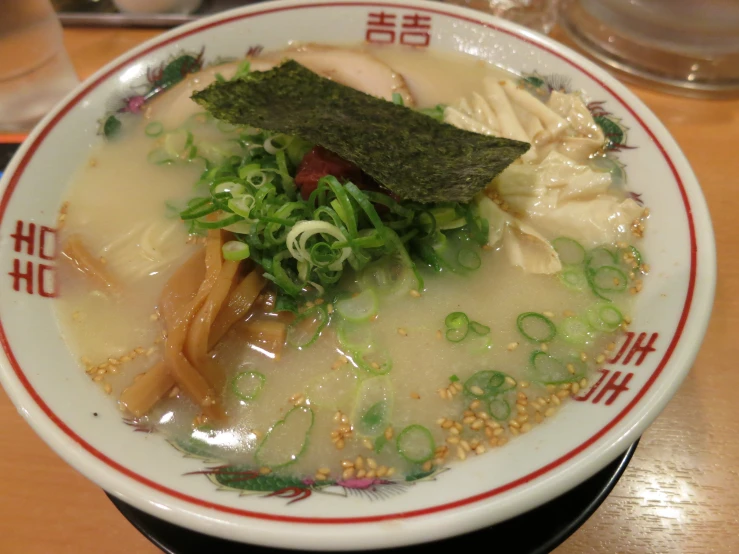 an overhead view of soup in a bowl with vegetables and noodles