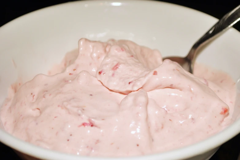 a bowl with a spoon filled with some kind of food