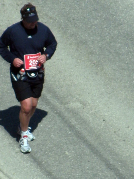 a man running on the street with a red sign over his left stomach