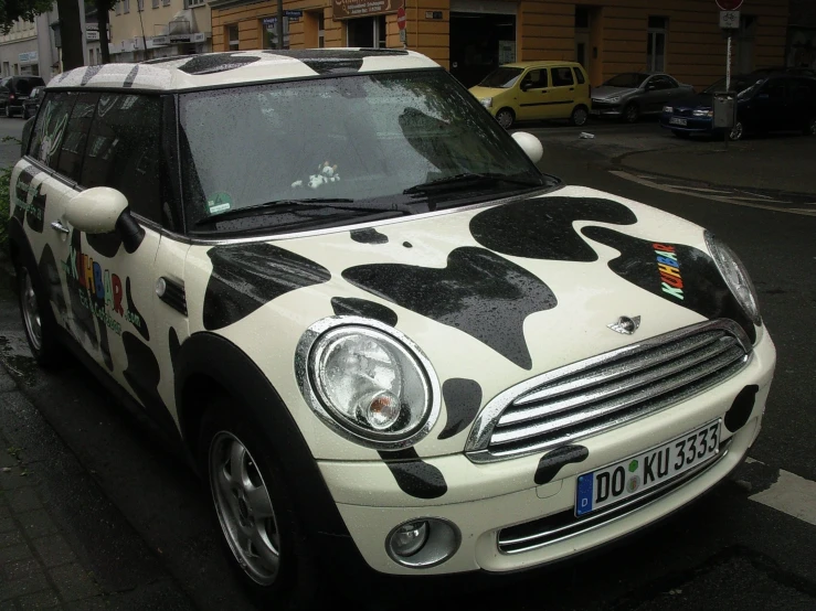 the mini parked on the side of the street is decorated with the colors of the flag