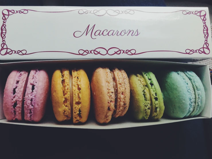 five fancy macaroons in a box on display
