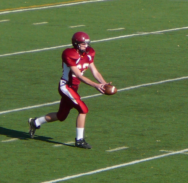 there is a male football player holding a ball