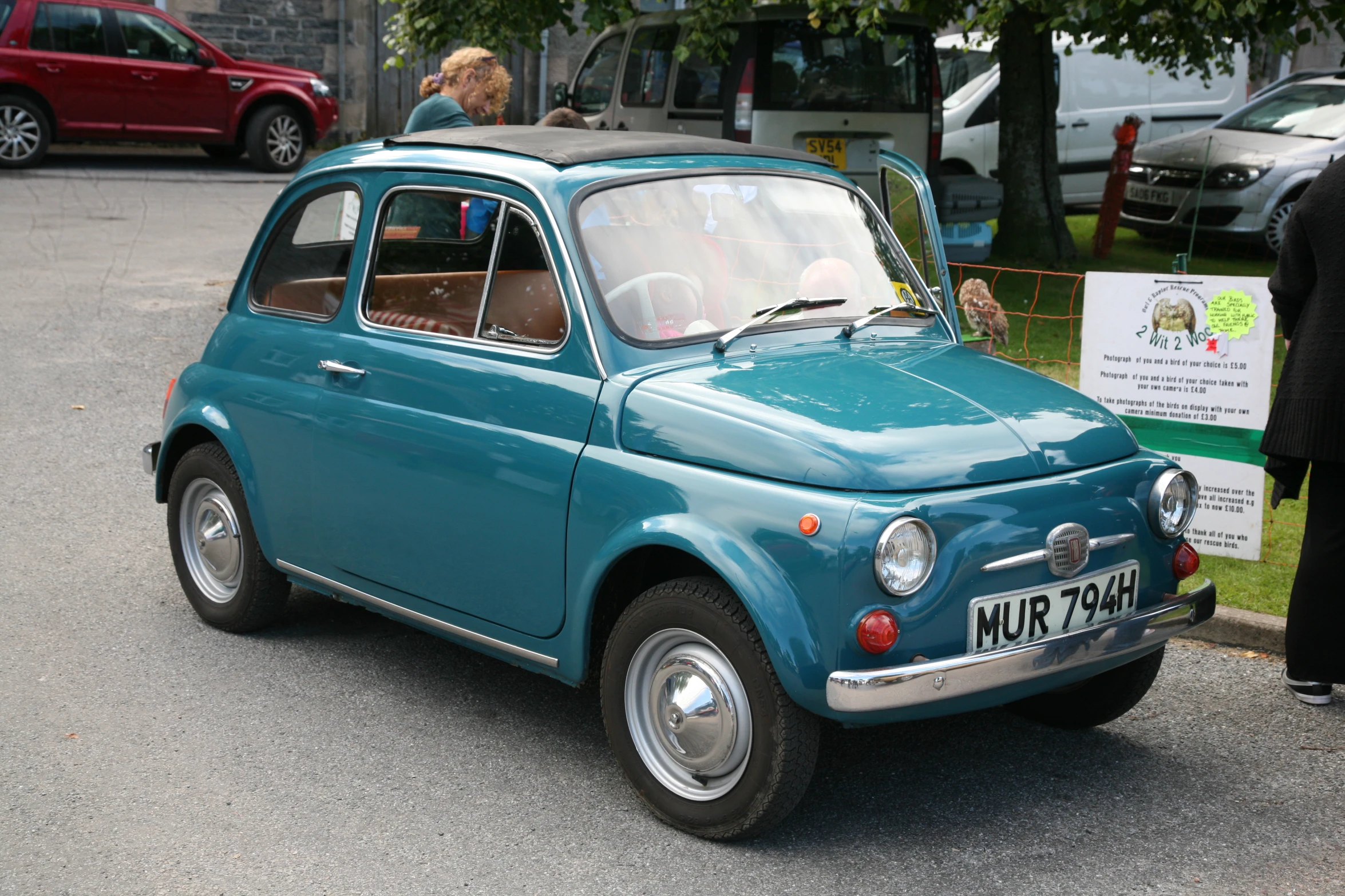 there is an old blue car that is parked next to a red car