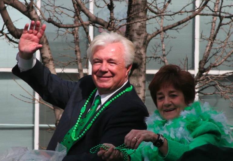 the two people are waving as they walk