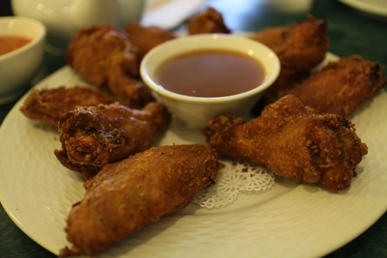 three fried foods are on a white plate with dipping sauce