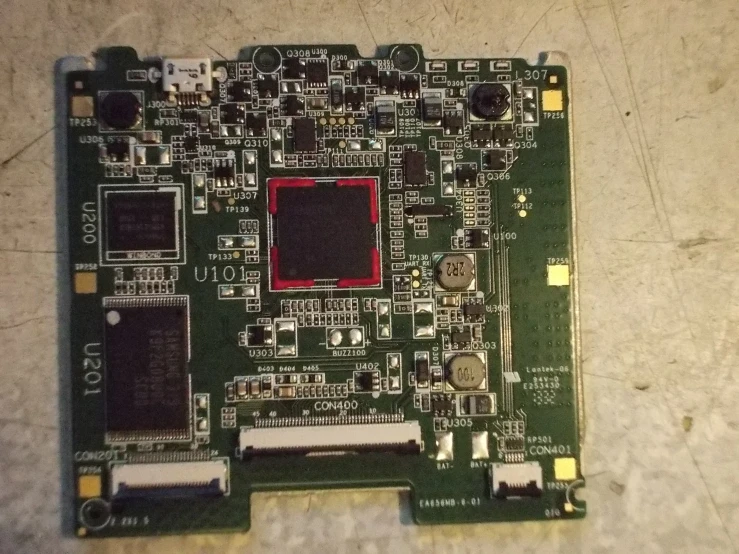 an old motherboard with red chip that is sitting on the floor