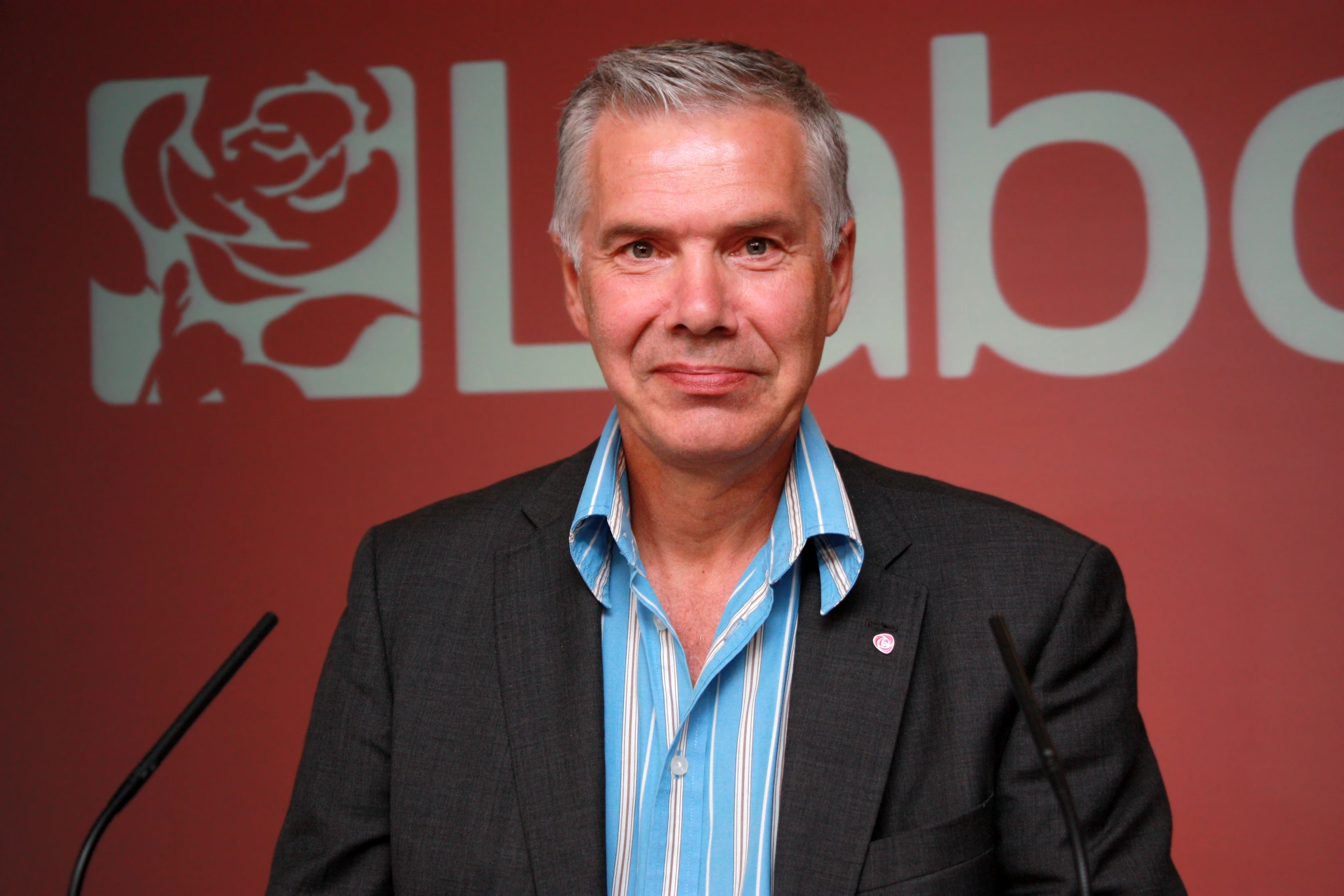 a man who is smiling next to a microphone