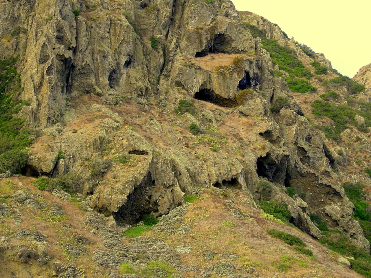 a rocky hillside with many small caves