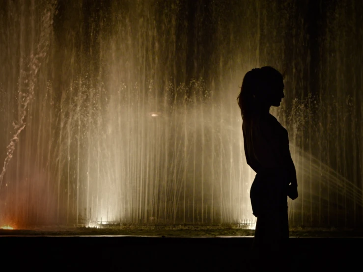 a man looks at the water spouting from underneath