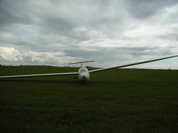 an airplane parked on the grass near some poles
