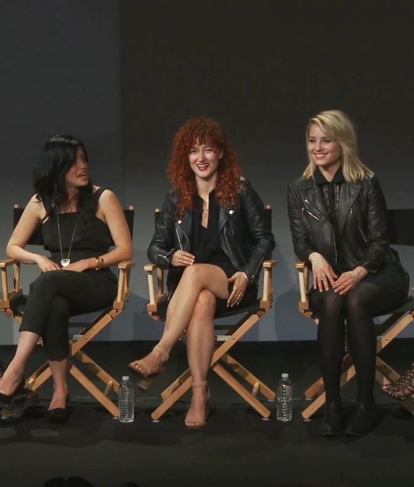 four people sit on chairs at an event