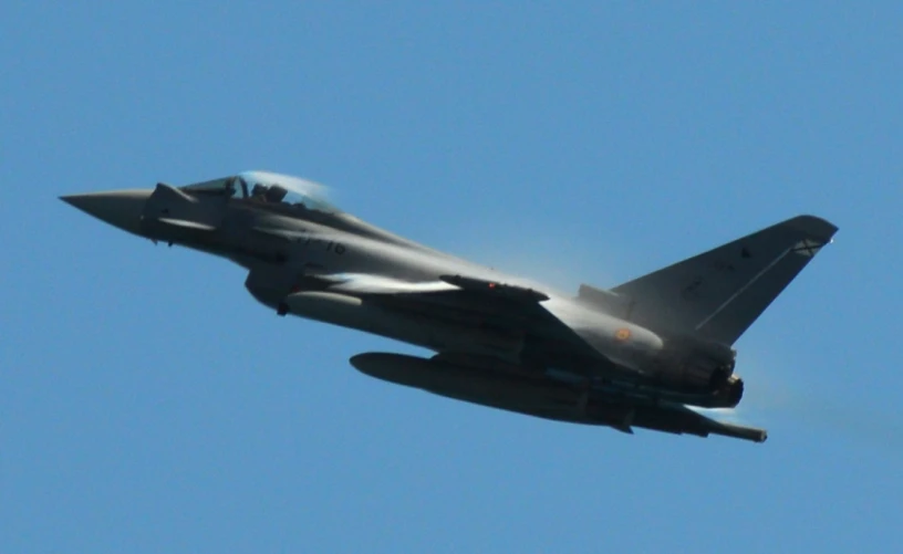 a fighter jet flies through the sky with no clouds