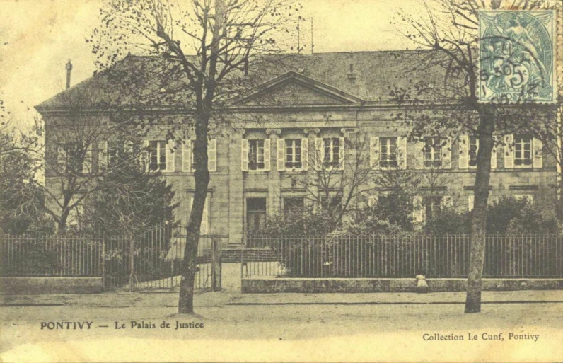 a building with fence and trees in front