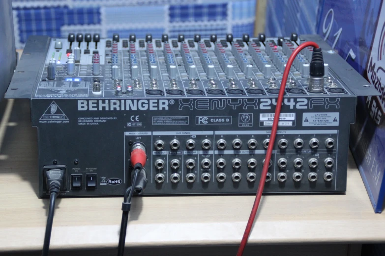 a pair of red wire plugged into a sound board