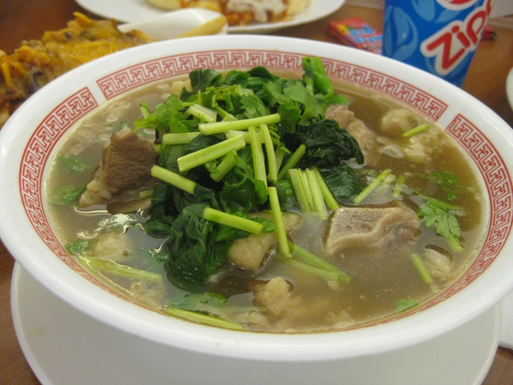 a bowl full of soup and vegetables on a table