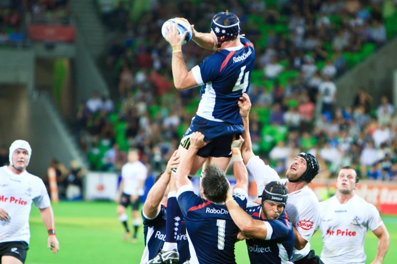 a bunch of people in the stands playing rugby