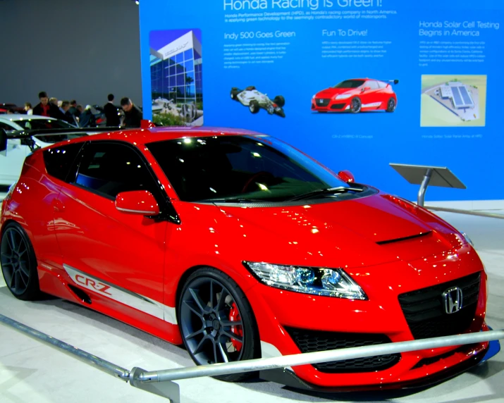 a red car parked next to an exhibit wall