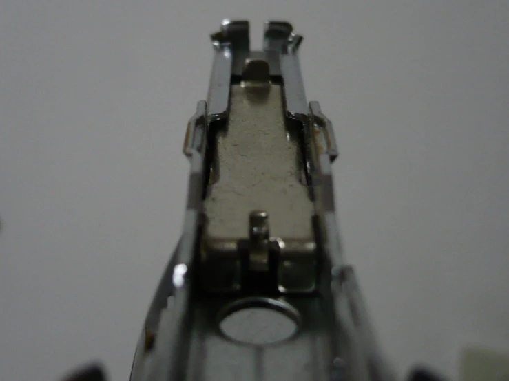 the silver gun appears to be in focus with the white background