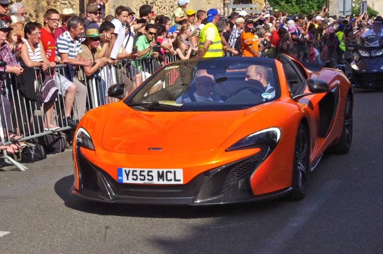 a orange sports car driving down a road