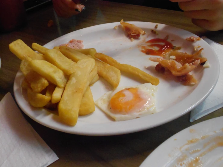 someones leftovers of food sitting on a plate with fried eggs