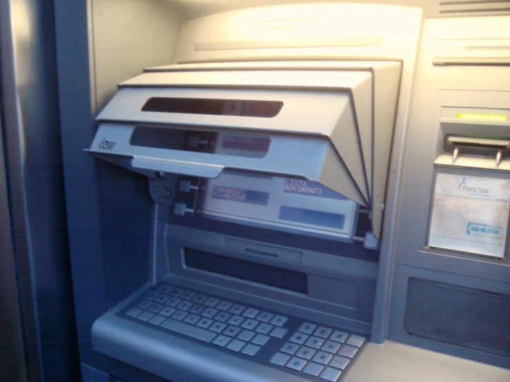 an old style atm machine next to a paper machine