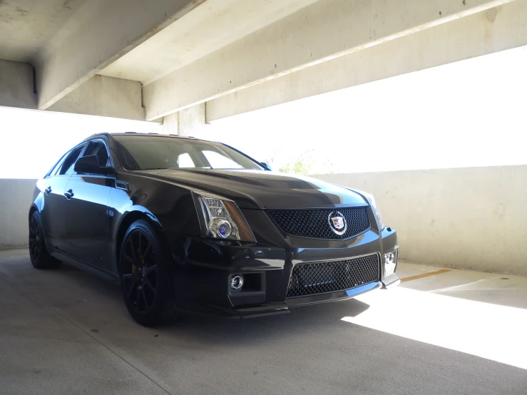 a black sports car sits parked in an underpass