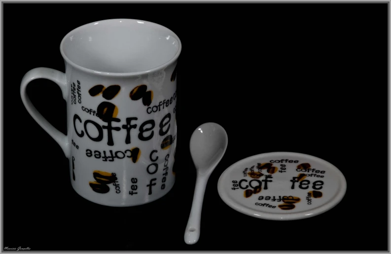 a cup and spoon and a plate with the word coffee on it