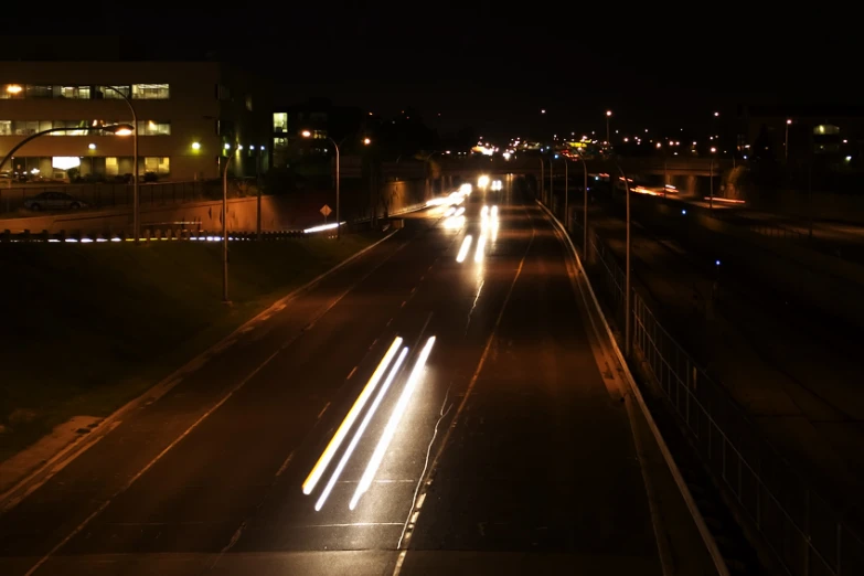 a night time highway with cars and trucks on the road