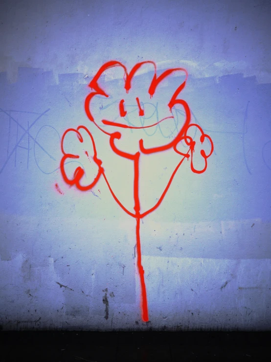 a graffiti spray painted red on a white wall