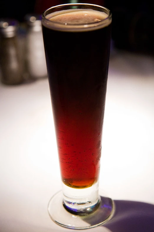a dark colored beverage is in a glass