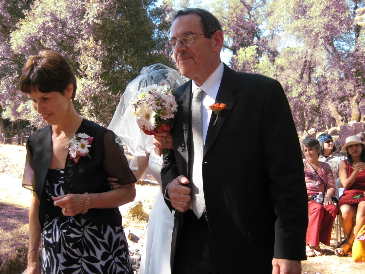 a man and woman walking together in front of a crowd