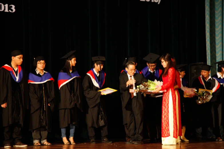 graduates receiving degrees from students on stage