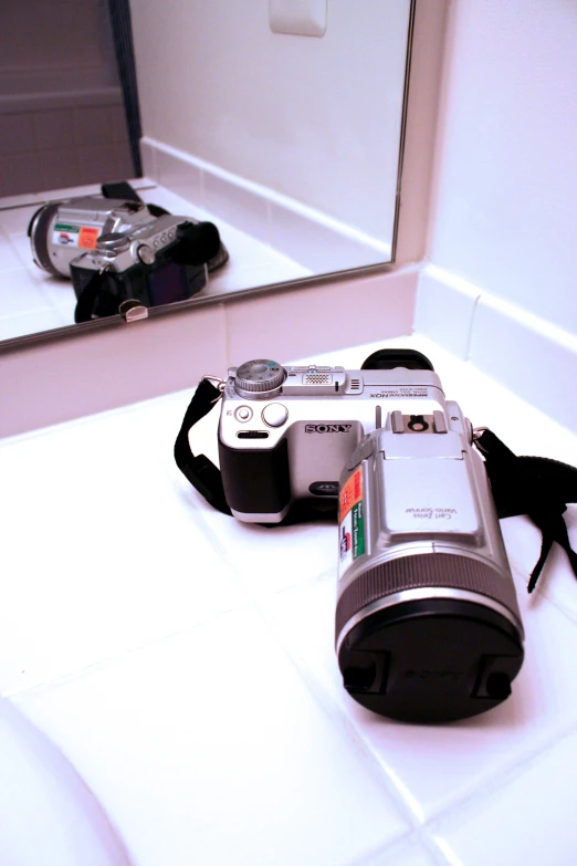 a camera sitting on a counter in front of a mirror