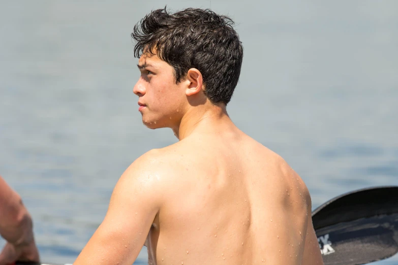 shirtless male  holding an open water ski