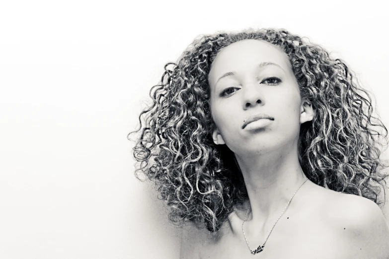 a woman with her hair curly and eyes closed wearing a necklace