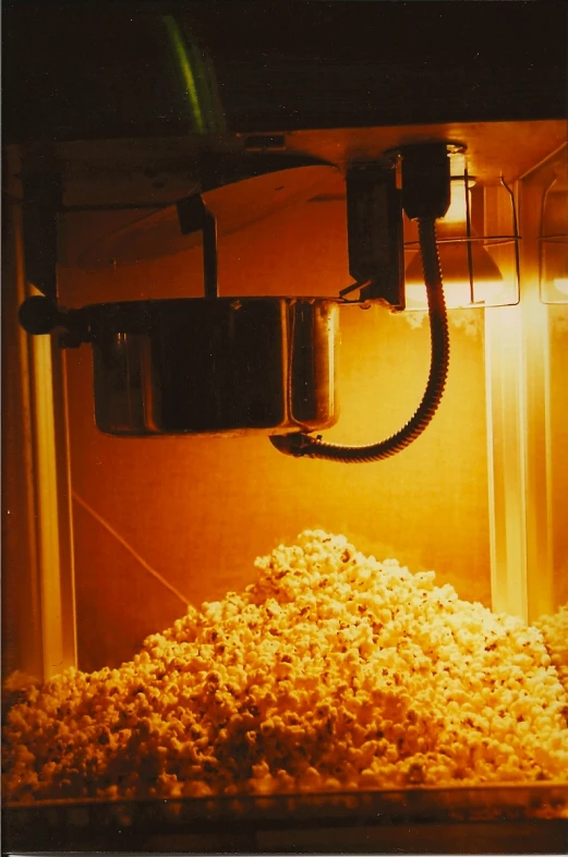 a bowl filled with popcorn is sitting under a computer