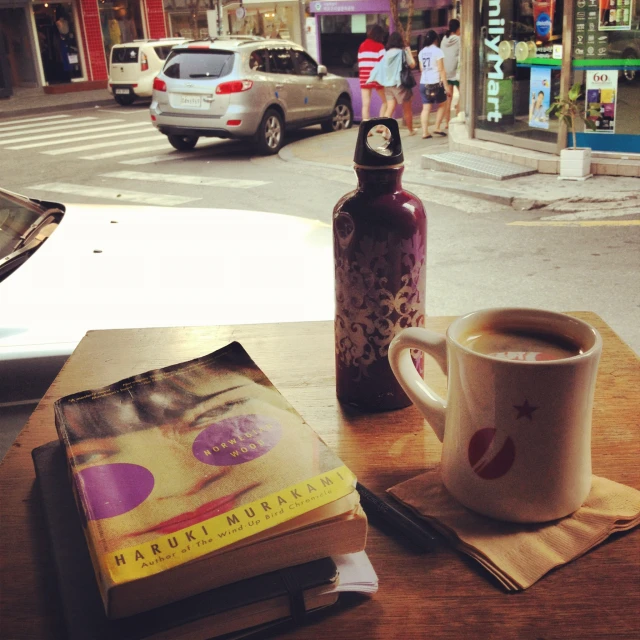 coffee cup, mug and book are on the table