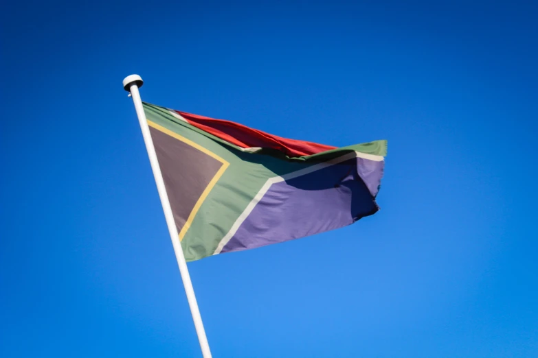 the top of a multi - colored flag with sky in background