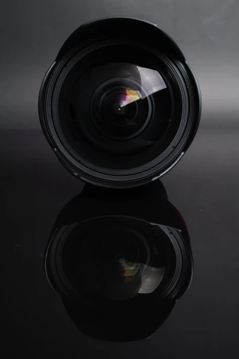 a canon lens is shown sitting on a black surface